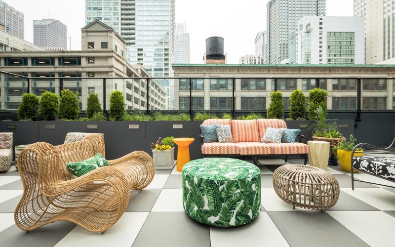 a rooftop lounge space with a view of a city
